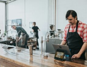 Waiter in cafe looking at a computer